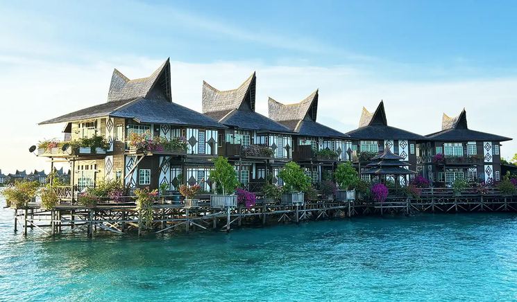 Row of two-storey Family Villa Suites over the water, with flowers along the balconies