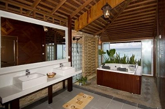 Bathroom with twin basins and a bathtub beside a window
